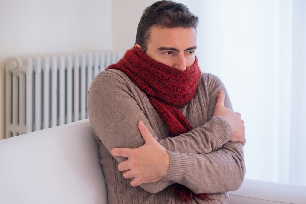 Man freezing and shivering in scarf