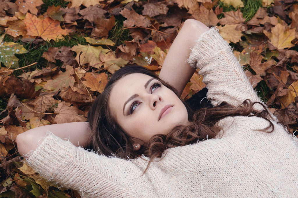 Woman laying in yard on leaves